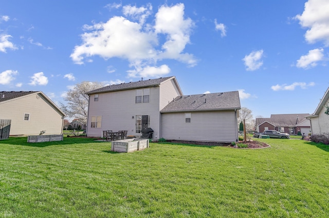rear view of house featuring a yard