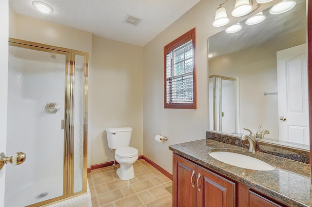 bathroom featuring vanity, baseboards, toilet, a shower stall, and visible vents
