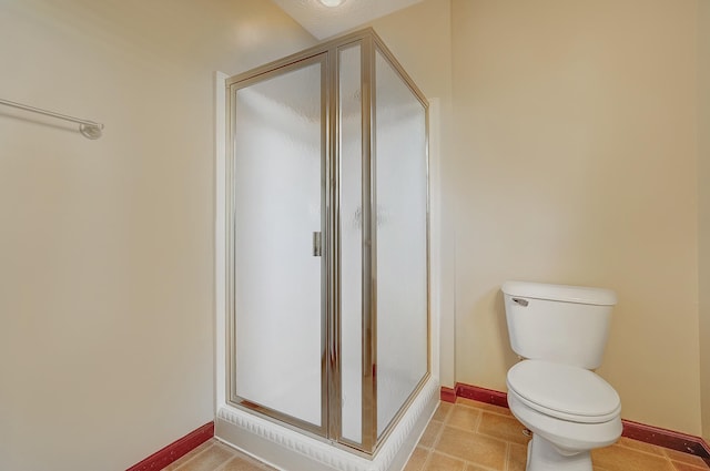 full bathroom with toilet, baseboards, and a stall shower