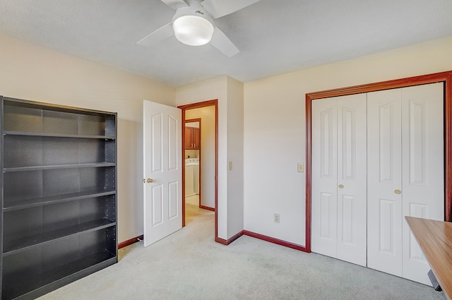 unfurnished bedroom with a closet, baseboards, ceiling fan, carpet floors, and washer / dryer
