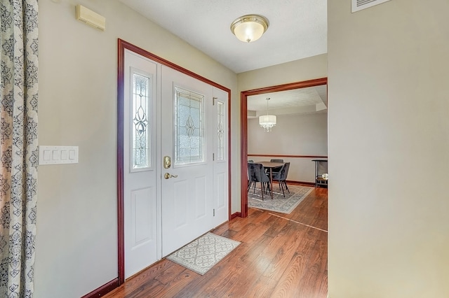 entrance foyer featuring wood-type flooring and baseboards