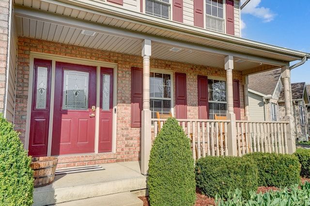 entrance to property with brick siding and covered porch