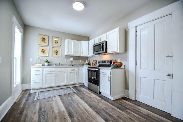 kitchen featuring white cabinets, stainless steel appliances, and dark hardwood / wood-style flooring