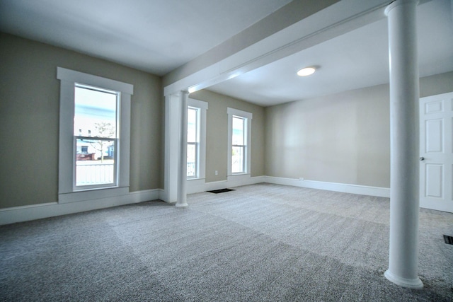 carpeted empty room featuring decorative columns