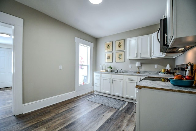 kitchen featuring stove, sink, white cabinetry, and dark hardwood / wood-style floors