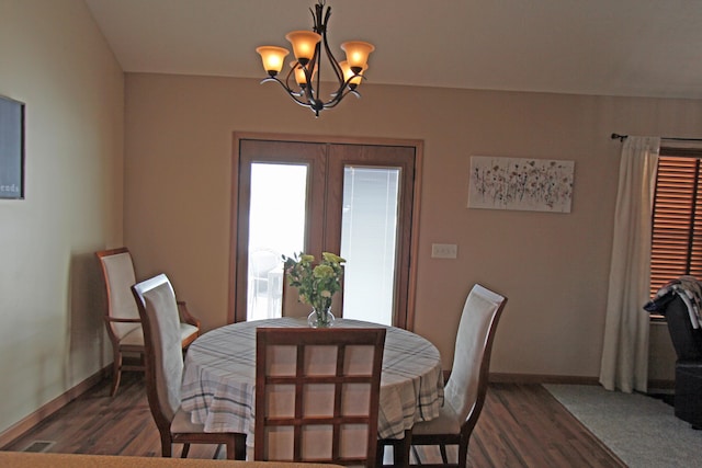 dining space featuring a notable chandelier, dark wood-style flooring, and baseboards