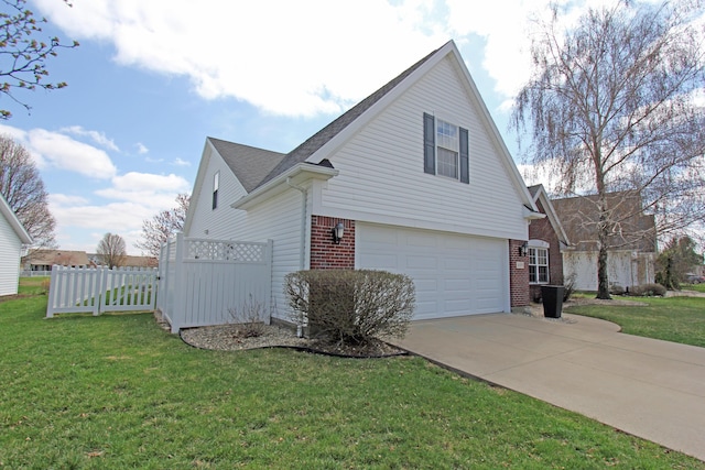 609 Lambert Dr, Piqua, OH 45356 - view of side of home featuring concrete driveway, fence, brick siding, a garage, and a lawn