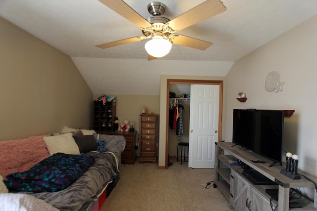 bedroom featuring lofted ceiling, a closet, light carpet, and ceiling fan