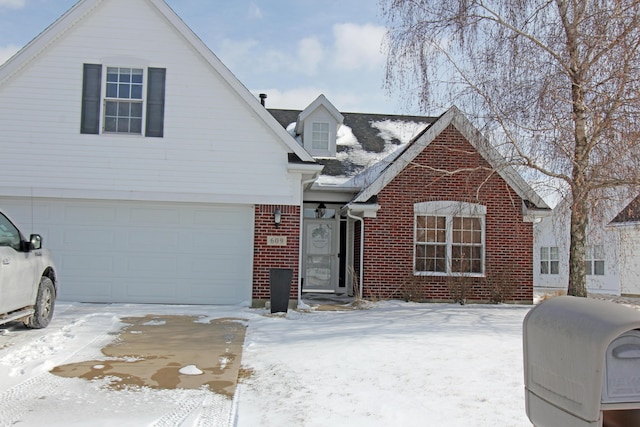 view of front of property with a garage, brick siding, and heating fuel