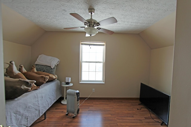 bedroom featuring dark wood finished floors, vaulted ceiling, a textured ceiling, ceiling fan, and baseboards