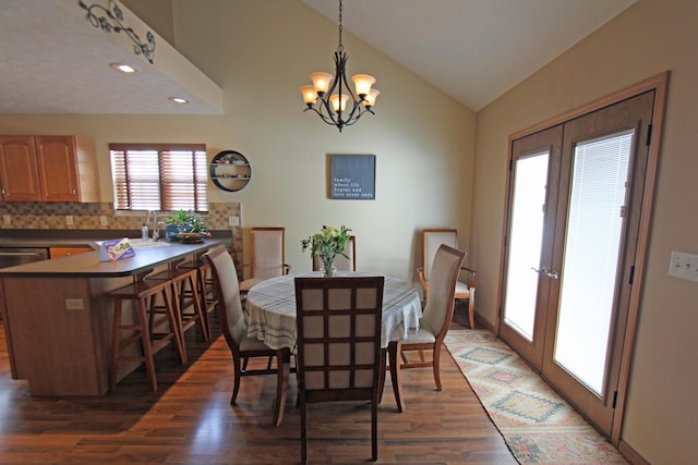 dining room featuring lofted ceiling, recessed lighting, dark wood-style flooring, french doors, and an inviting chandelier