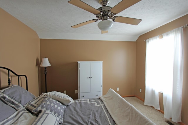 bedroom with visible vents, light carpet, vaulted ceiling, a textured ceiling, and baseboards