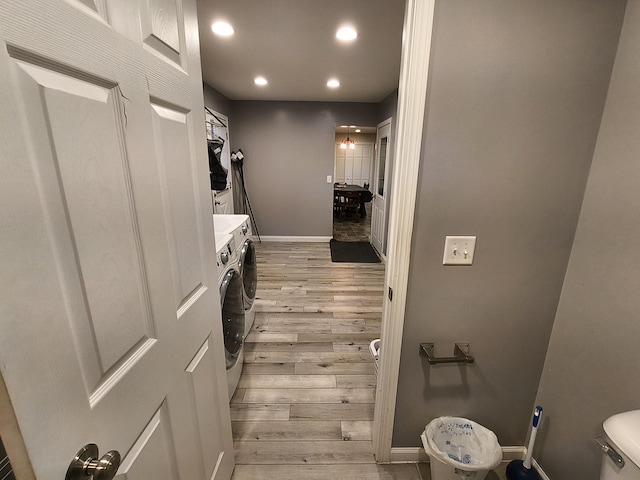 laundry area with washer and dryer and light hardwood / wood-style floors