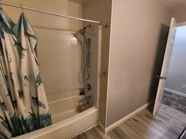 bathroom with shower / bathtub combination with curtain and wood-type flooring