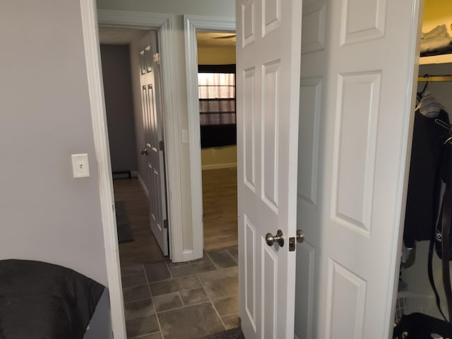 hallway featuring dark tile patterned floors