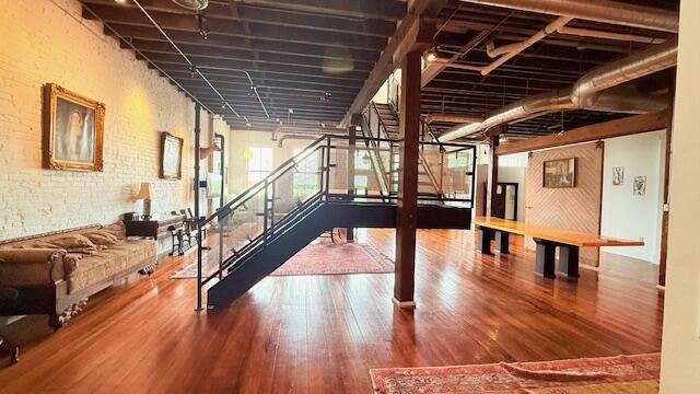 basement with wood finished floors and brick wall