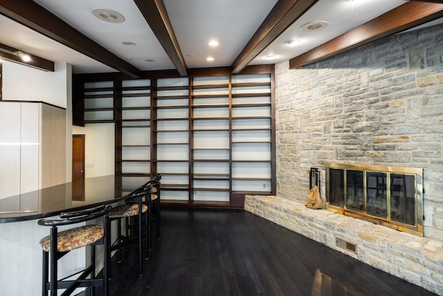125 Hawthorne Rd, Springfield, OH 45504 - unfurnished living room featuring beamed ceiling, dark wood-style floors, and a stone fireplace