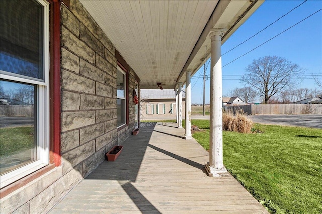 wooden deck featuring fence, a porch, and a yard
