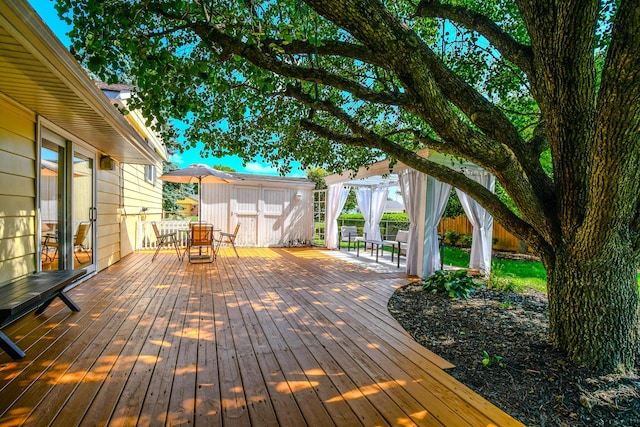 1138 Edgebrook Ave, New Carlisle, OH 45344 - wooden terrace featuring outdoor dining area, a shed, and a fenced backyard