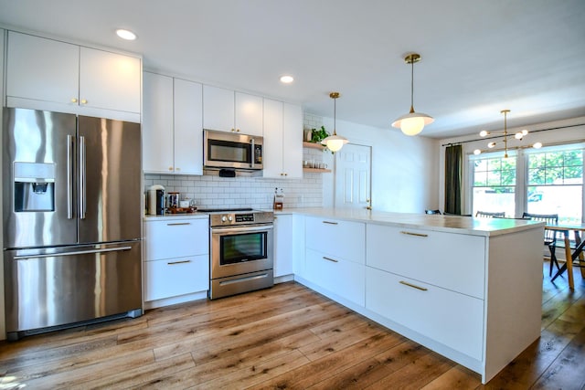1138 Edgebrook Ave, New Carlisle, OH 45344 - kitchen with stainless steel appliances, a peninsula, light countertops, backsplash, and white cabinets