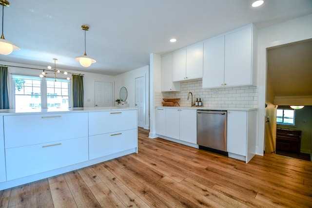 1138 Edgebrook Ave, New Carlisle, OH 45344 - kitchen with stainless steel dishwasher, light countertops, light wood-type flooring, backsplash, and white cabinetry