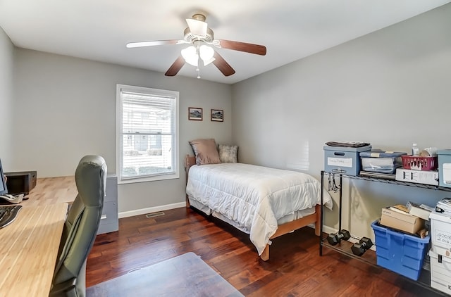 bedroom featuring visible vents, baseboards, ceiling fan, and wood finished floors