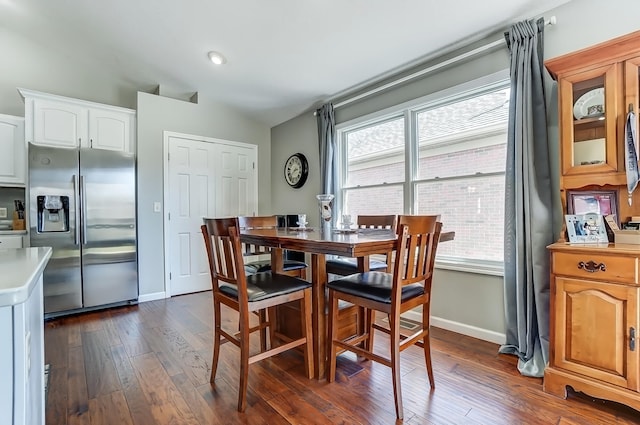 dining space with dark wood-style flooring and baseboards