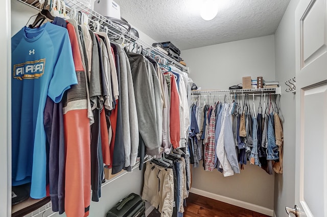 walk in closet with wood finished floors