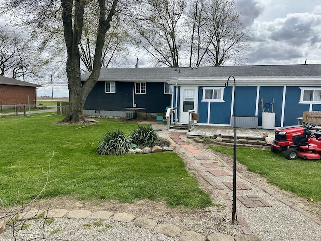 view of front of home with cooling unit and a front yard