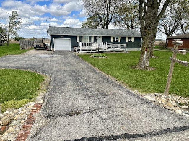 ranch-style home featuring fence, an attached garage, driveway, a porch, and a front yard