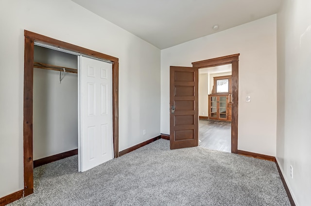 unfurnished bedroom with a closet, carpet flooring, and baseboards