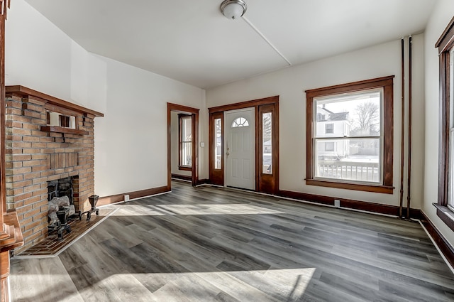 entryway with a fireplace, wood finished floors, and baseboards