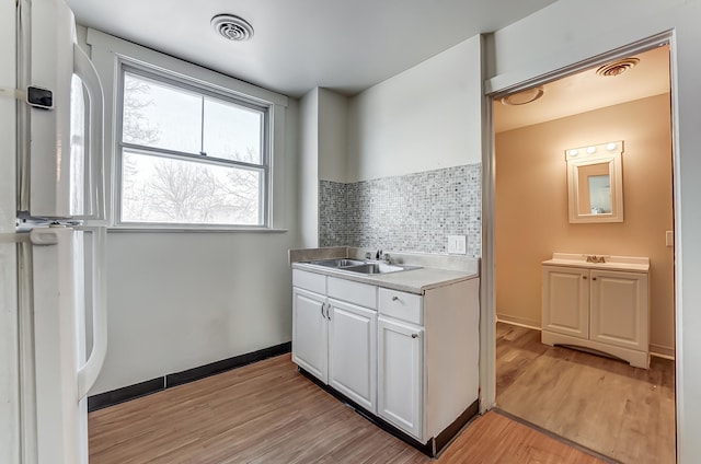 bathroom featuring tasteful backsplash, visible vents, vanity, and wood finished floors