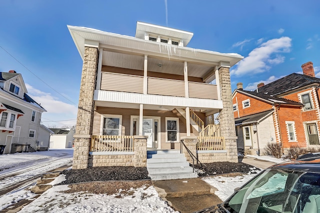 view of front of house featuring a balcony, a porch, and an outdoor structure