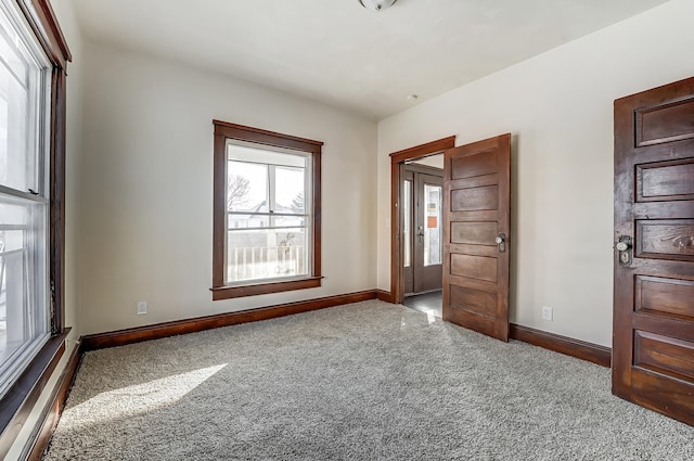 carpeted empty room with baseboards