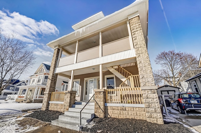 view of property with a balcony and covered porch