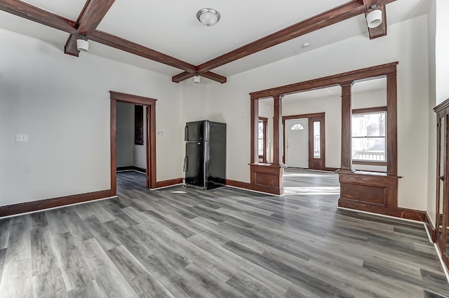 interior space with coffered ceiling, wood finished floors, baseboards, beamed ceiling, and decorative columns