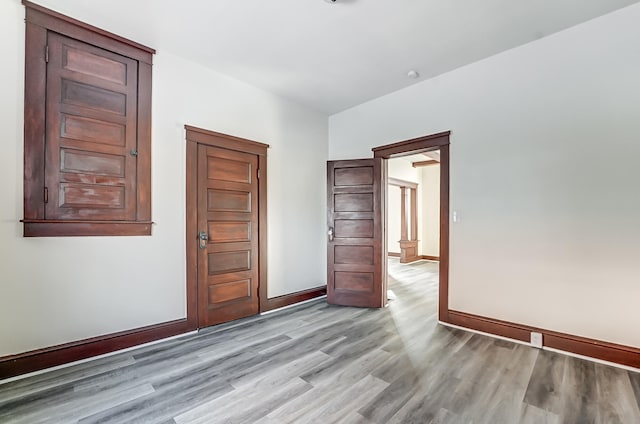 spare room with light wood-style floors and baseboards