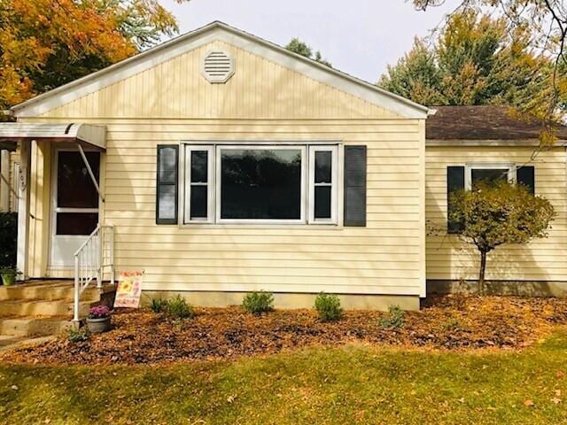 view of home's exterior with entry steps and a lawn