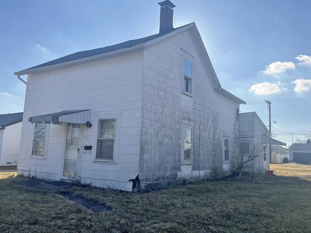 view of property exterior featuring a chimney and a yard