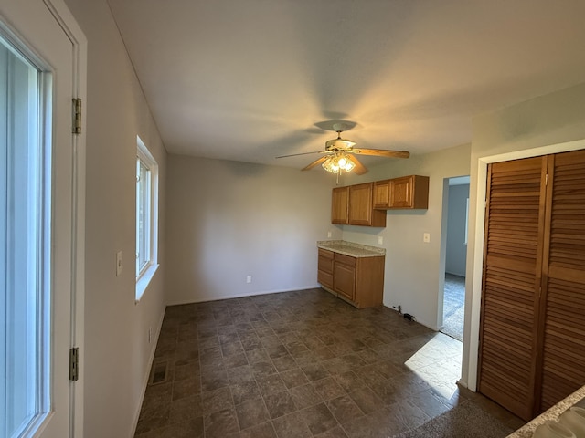 118 S Troy St, Bellefontaine, OH 43311 - kitchen with a ceiling fan, brown cabinets, light countertops, and stone finish floors