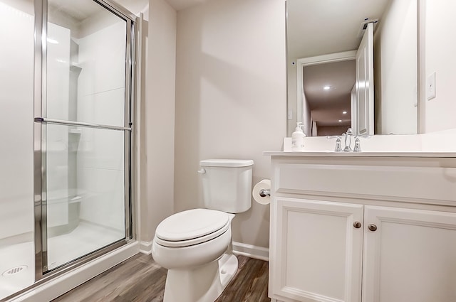 bathroom featuring vanity, wood-type flooring, toilet, and a shower with shower door