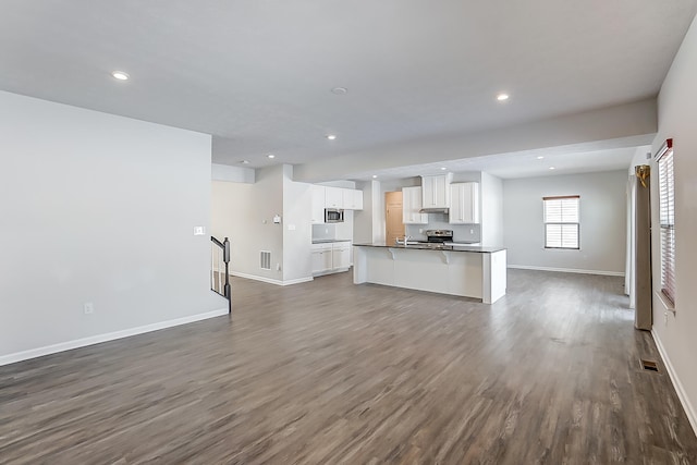 unfurnished living room with dark wood-type flooring