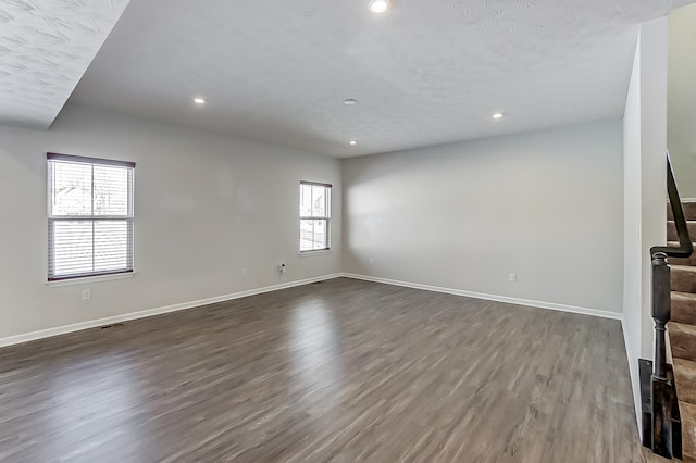 unfurnished living room featuring dark hardwood / wood-style floors and a textured ceiling