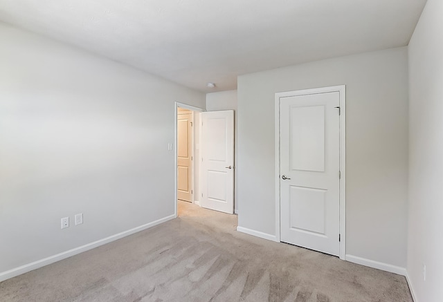 unfurnished bedroom featuring light carpet