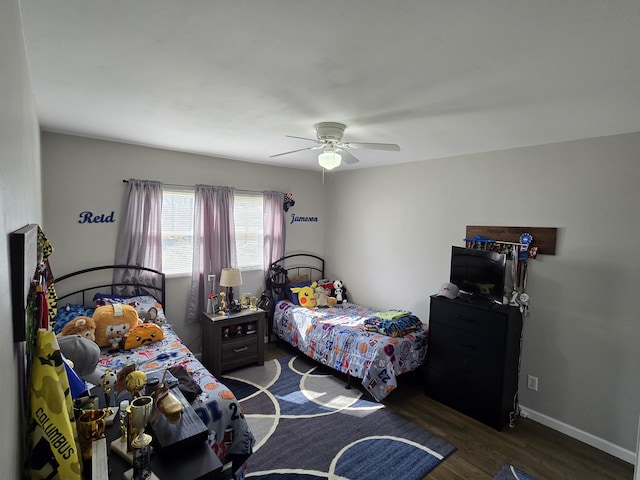 bedroom with ceiling fan, wood finished floors, and baseboards