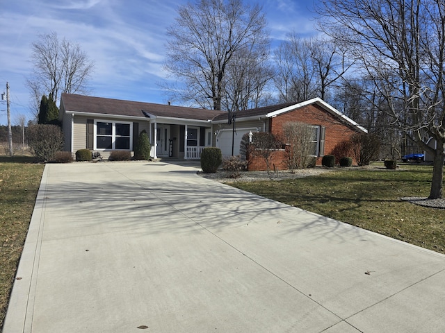 ranch-style home with brick siding, a porch, a front yard, a garage, and driveway