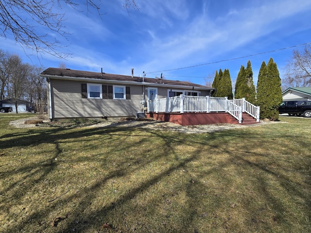 rear view of house with a lawn and a deck