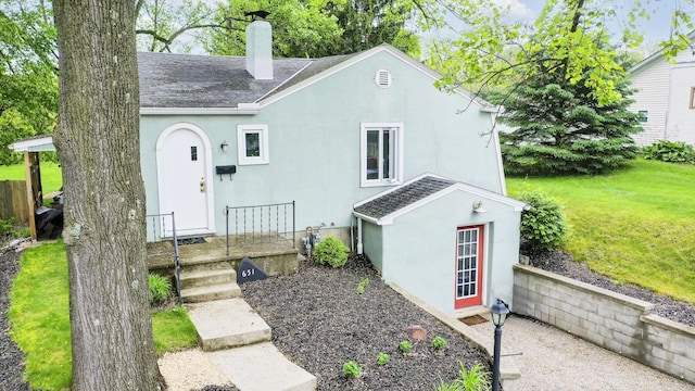 651 Eastern Ave, Bellefontaine, OH 43311 - view of front of home with roof with shingles, a chimney, stucco siding, and a front lawn
