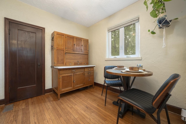 651 Eastern Ave, Bellefontaine, OH 43311 - dining space featuring light wood-style floors, baseboards, a textured ceiling, and a textured wall